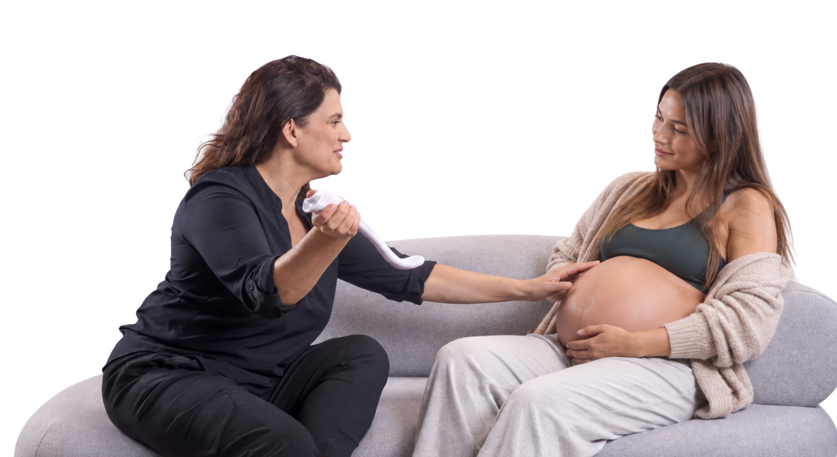 Profesional del parto mostrando el masajeador perineal Perimom a una mujer embarazada